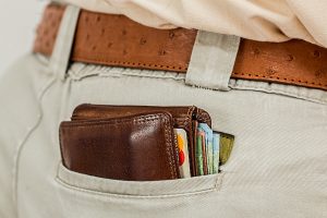 Man's back pocket with credit card filled wallet peaking out.