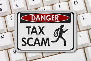 Tax scam danger sign, A black and white danger sign with text Tax Scam and theft icon on a keyboard